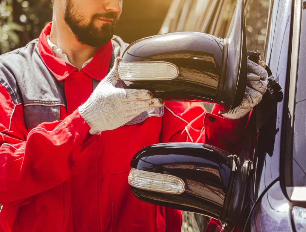 Homem trocando retrovisor de carro