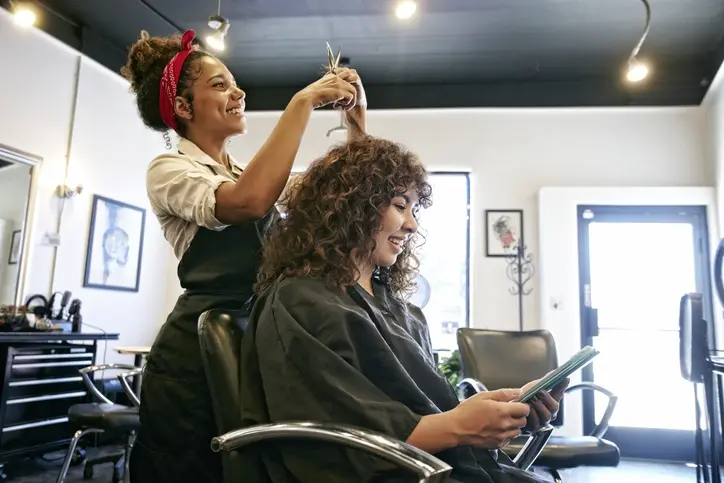 Cabeleireira cortando o cabelo de mulher
